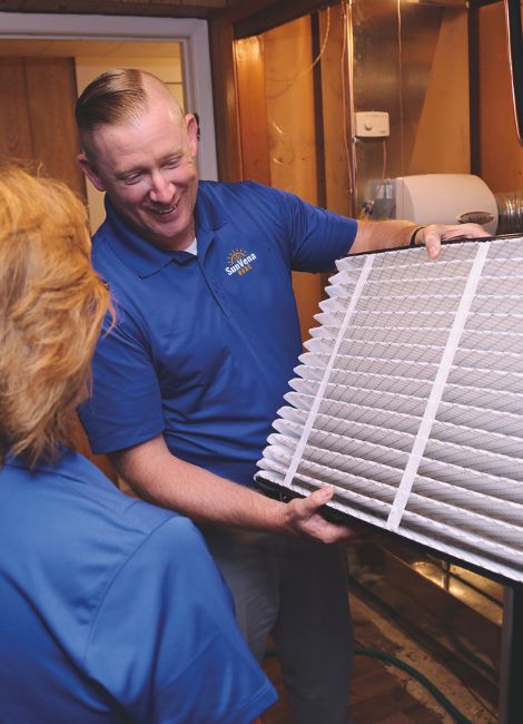 SunVena HVAC technician showing a homeowner a pleated air filter