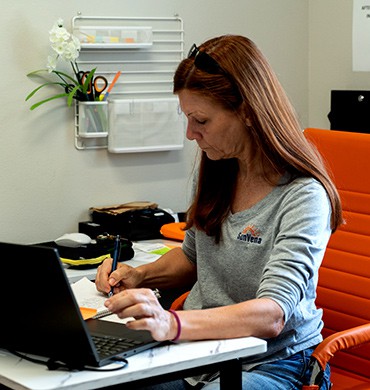 sunvena-hvac-dealer-coordinator SunVena HVAC team member working at a laptop in the office